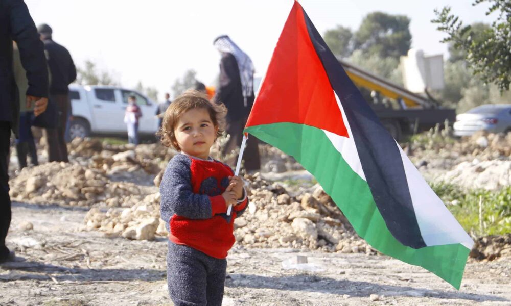 Budak memegang bendera Palestine