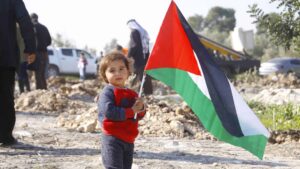 Budak memegang bendera Palestine